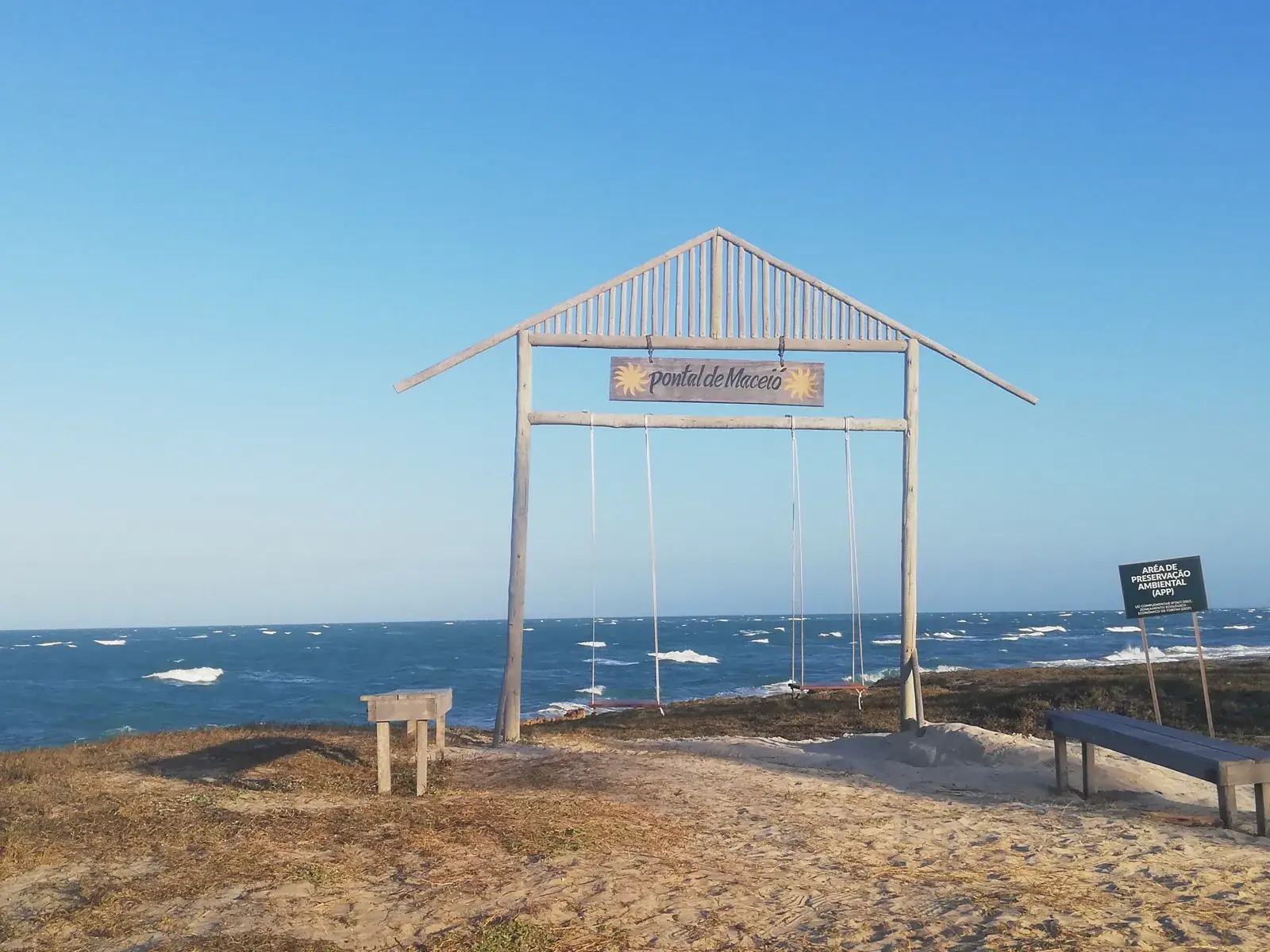 Balanço de madeira no alto da falésia, de frente para o mar