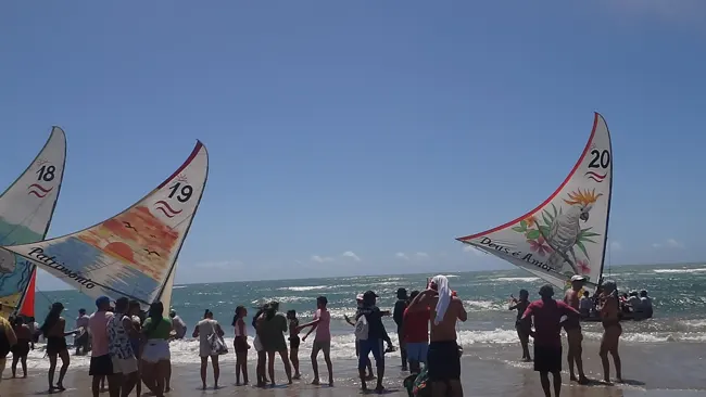 Velas artesanais alinhadas na praia