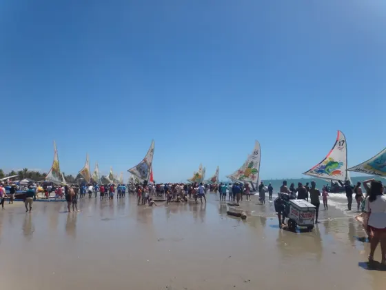 Movimento de jangadas e público à beira-mar